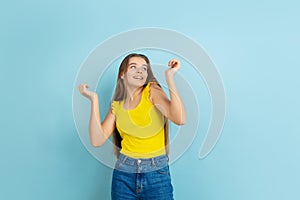 Caucasian teen girl portrait isolated on blue studio background