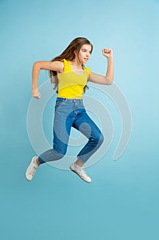 Caucasian teen girl portrait isolated on blue studio background