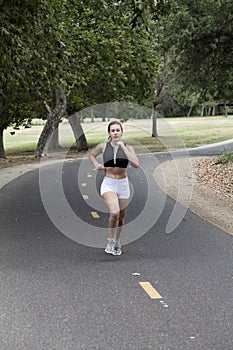 Caucasian Teen Girl Running On Bike Path In Park