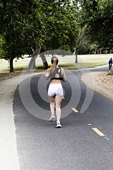 Caucasian Teen Girl Running On Bike Path In Shorts