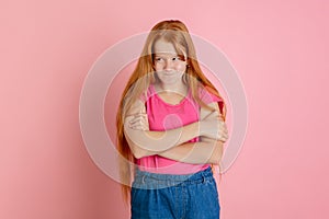 Caucasian teen girl`s portrait isolated on coral pink studio background.