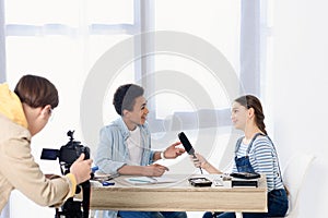 caucasian teen kid conducting interview with african american friend