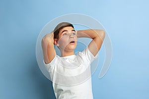 Caucasian teen`s portrait isolated on blue studio background