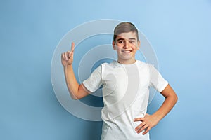 Caucasian teen`s portrait isolated on blue studio background