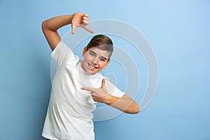 Caucasian teen`s portrait isolated on blue studio background