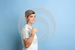 Caucasian teen`s portrait isolated on blue studio background