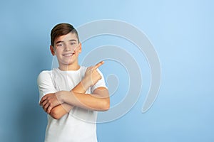 Caucasian teen`s portrait isolated on blue studio background