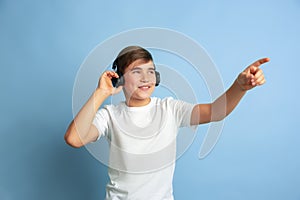 Caucasian teen`s portrait isolated on blue studio background