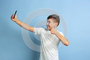 Caucasian teen`s portrait isolated on blue studio background