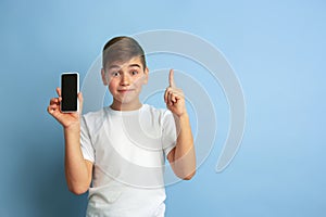 Caucasian teen`s portrait isolated on blue studio background