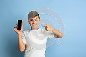 Caucasian teen`s portrait isolated on blue studio background