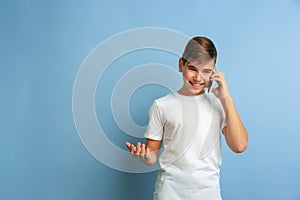 Caucasian teen`s portrait isolated on blue studio background