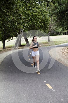 Caucasian Teen Woman Running On Bike Path In Park