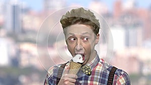 Caucasian teenage boy eating an ice cream.