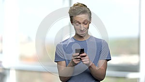 Caucasian teenage boy using mobile phone.