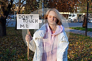 Caucasian teenage girl holding the inscription do not touch me in her hands. The concept of rage and protest in adolescents