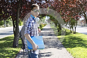 Caucasian teenage student boy with backpack going to high school. Secondary education