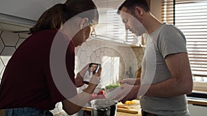 Caucasian teenager girl and her father having video call with mother while cooking.