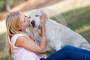 Caucasian teenager girl with old senior labrador dog in the park