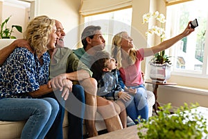 Caucasian three generation family taking a selfie while sitting on the couch at home