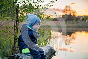 Caucasian toddle boy outdoors near lake in spring