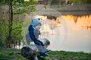 Caucasian toddle boy outdoors near lake in spring photo