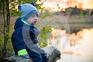 Cute toddle boy outdoors near lake photo