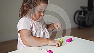 Caucasian toddler girl playing modeling play dough at home with mother. Homeschooling concept