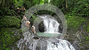 Caucasian tourists swimming in the tropical waterfall in Costa Rica.