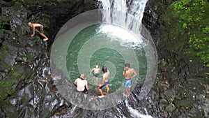 Caucasian tourists swimming in the tropical waterfall in Costa Rica.