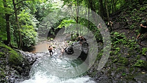 Caucasian tourists swimming in the tropical waterfall in Costa Rica.