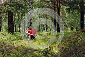 Caucasian traveler drinks coffee or tea on camping resting in forest. Tourism and camping concept