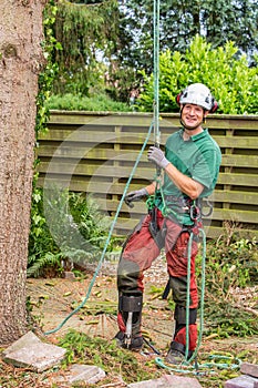 Dutch arborist with climbing equipment in garden