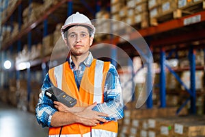 Caucasian warehouse worker standing in a large warehouse distribution center