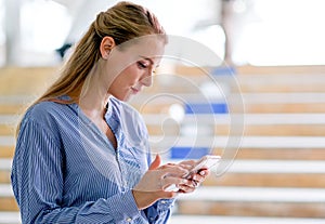 Caucasian white beautiful business woman look at her mobile phone and stand at sky train walk way, also expressed boring emotion