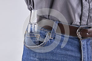 caucasian white male person with hand spray sanitizer at his jeans pocket. self protection at pandemic time. copy space