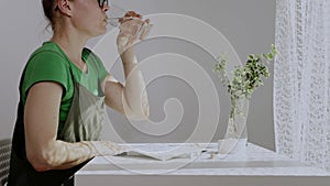 Caucasian woman of 40 years old is drinking glass of water.