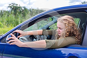 Caucasian woman adjusting side mirror of car