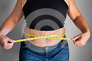 Caucasian Woman With Belly Fat Using Tape Measure