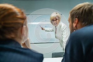 Caucasian woman blonde leads a presentation for colleagues.