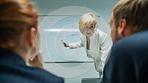 Caucasian woman blonde leads a presentation for colleagues.