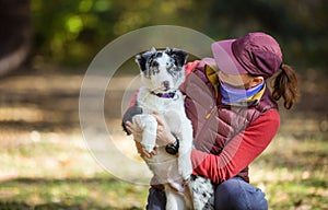 Caucasian woman with border collie puppy in autumn park