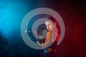 Caucasian woman boxing with colored gels and smoke