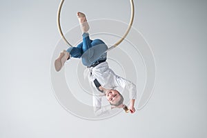 Caucasian woman in casual clothes on an aerial hoop.