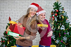 Caucasian woman celebrating holiday festival traditional with Christmas tree and gift box with friend