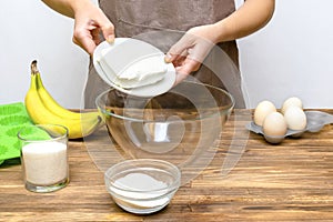 Caucasian woman chef in apron preparing ingredients for making cottage cheese banana muffins cupcakes casserole at home
