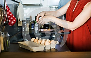 Caucasian woman cooking eggs in the kitchen