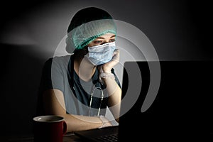 Caucasian woman doctor nurse in surgical mask looks tired, exhausted at night because of covid