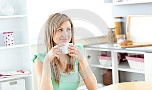 Caucasian woman drinking coffee in the kitchen