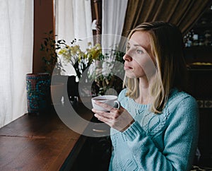 Caucasian; woman drinking coffee in the morning at restaurant